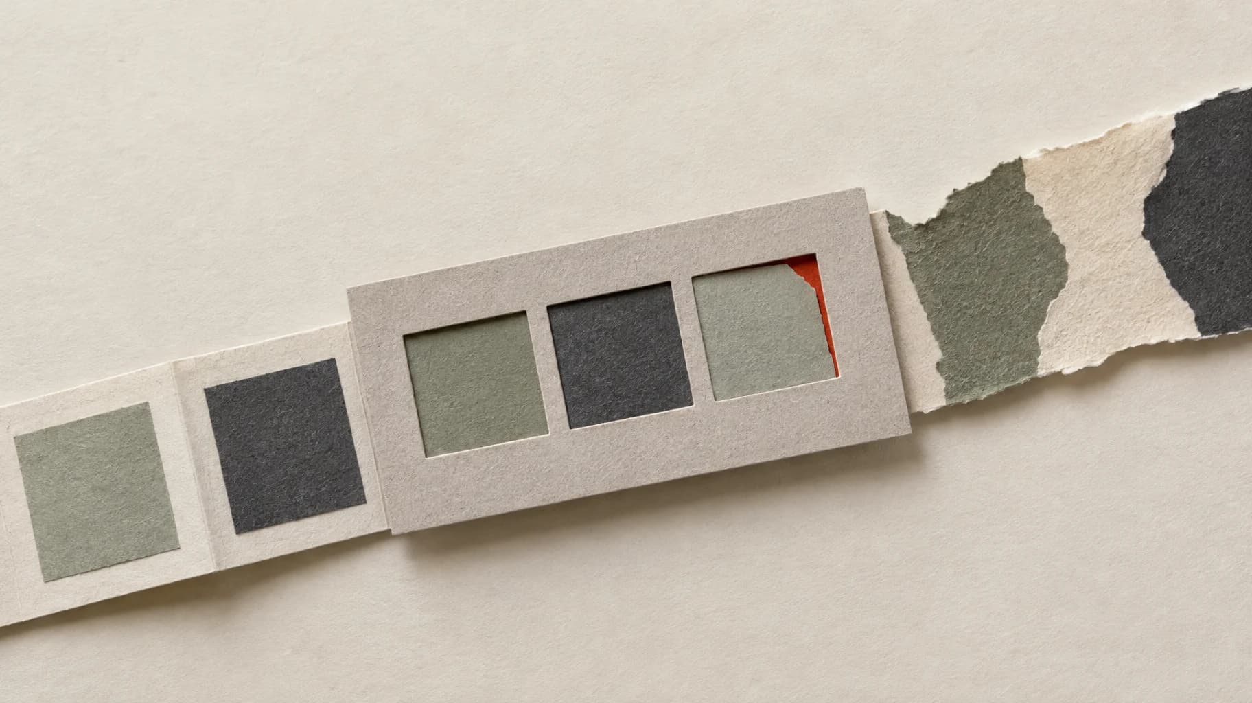 A card stencil checks folded paper panels; one fails to fit, while an irregular torn section extends beyond it.